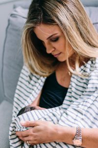 Mother breastfeeding with NuRoo nursing scarf. 